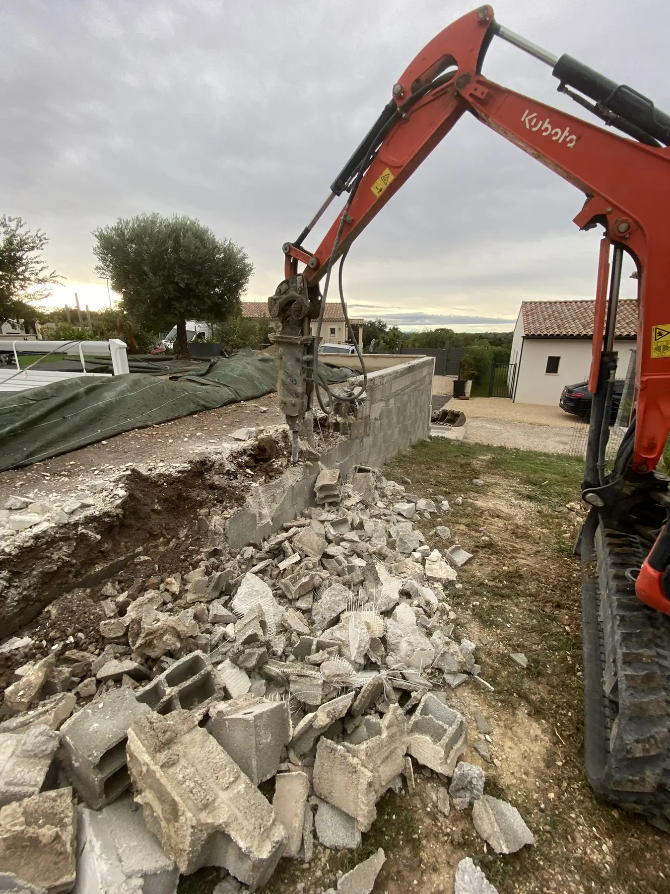 Démolition mécanique d’un ancien mur à Châteauneuf-du-Pape