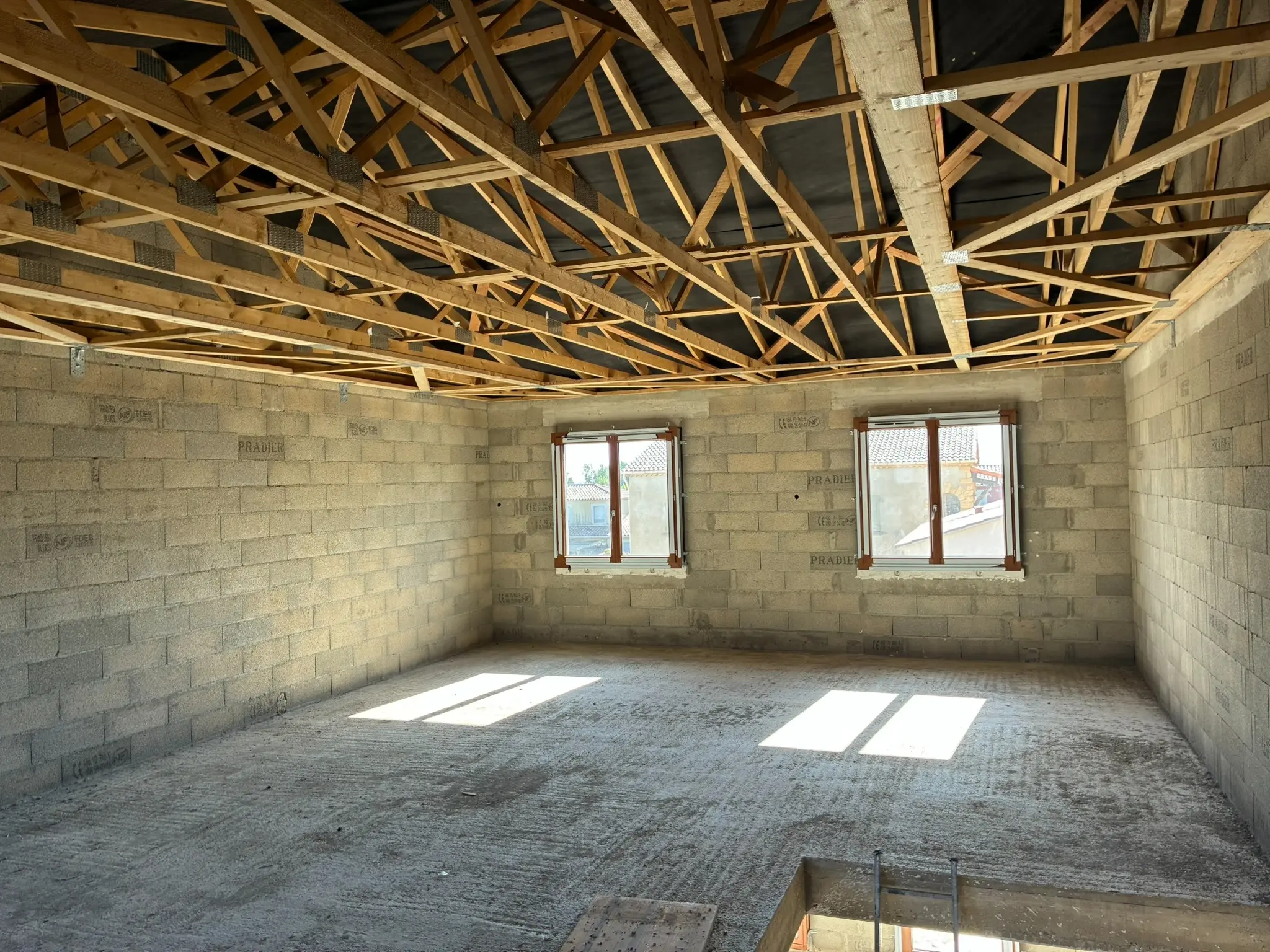 Vue intérieure sous charpente d’un logement neuf à Gaujac